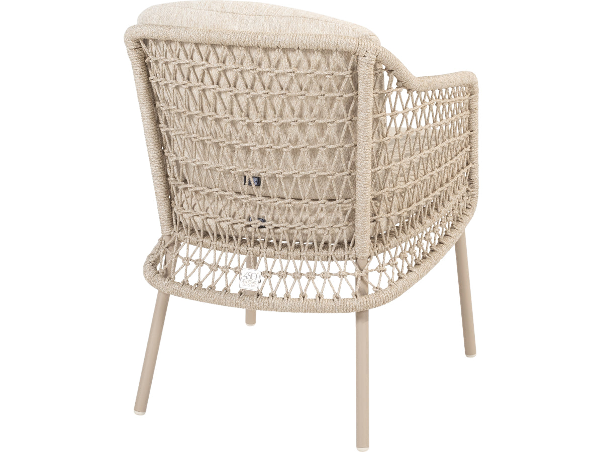 Puccini tuinstoel van 4 Seasons Outdoor van achteren, met licht open vlechtwerk en beige kussens.