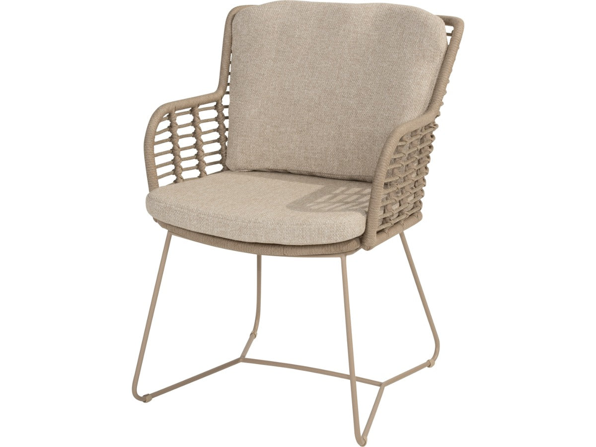 Fabrice tuinstoel van 4 Seasons Outdoor in Latte, schuin van voren, met gevlochten rug, beige kussens en sledepoten.