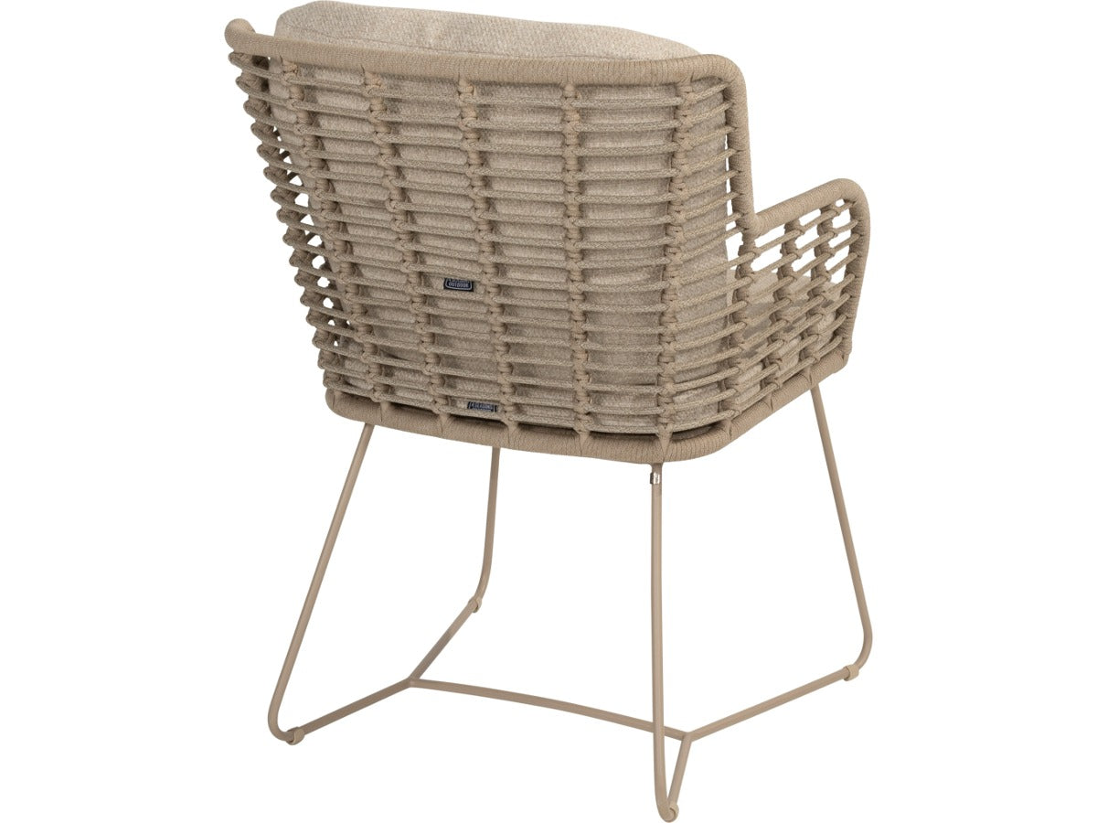 Fabrice tuinstoel van 4 Seasons Outdoor in Latte, van achteren, met gevlochten rug, beige kussens en sledepoten.