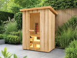 Fonteyn Retreat 150 houten buitensauna met glazen deur en verlicht interieur op een terras in een groene tuin.